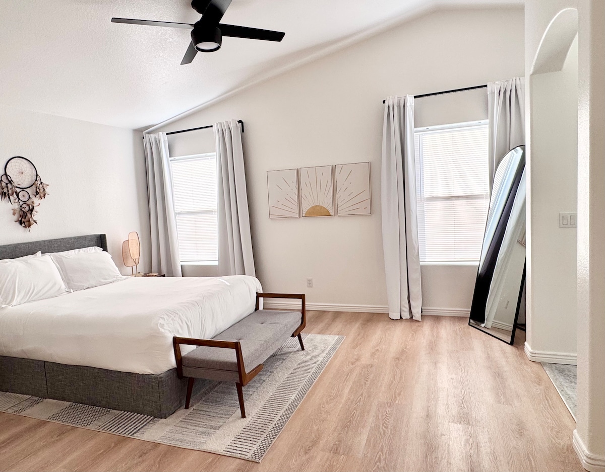 宽敞的主卧室，配备宽敞的卫生间和步入式衣帽间。 步入式衣帽间内有婴儿游戏床、梳妆台和衣架。