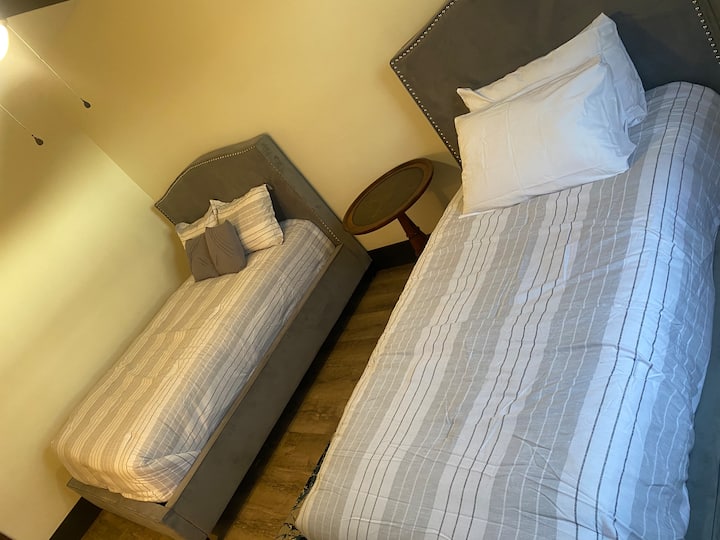 غرفة النوم الثانية في الطابق السفلي بسريرين بمقاس واحد + خزانة + حمام كامل. 