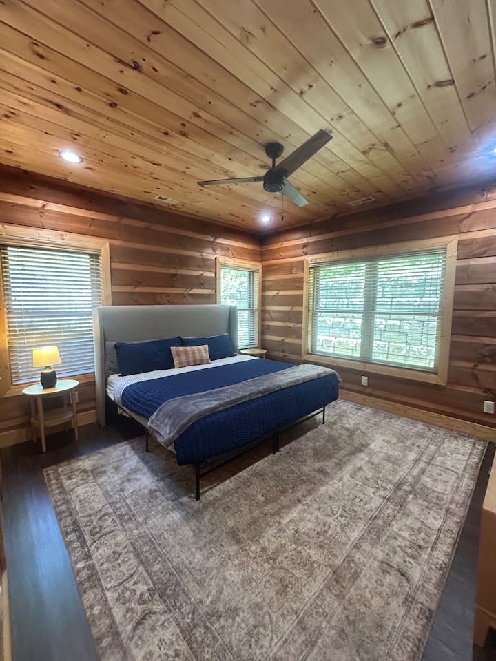 Bedroom 2: Main level king room with a TV and an attached bathroom featuring double vanities & tub/shower combo!