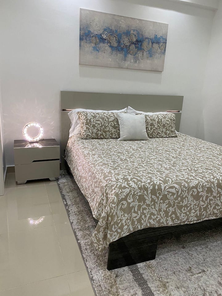 Dormitorio con cama tamaño king y luces en la cabecera