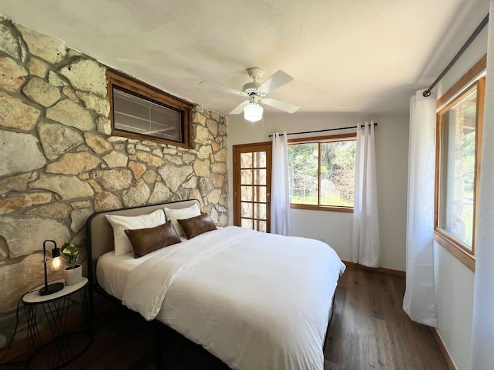 Este dormitorio se distingue por un verdadero muro de piedra. Está amueblado con una cama tamaño queen.