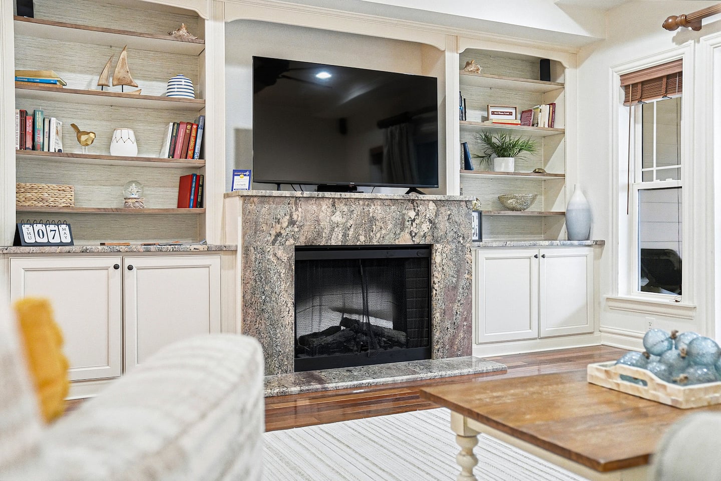 After sunset, gather around the fireplace for movie nights on the Roku TV, surrounded by custom built-ins and coastal warmth.