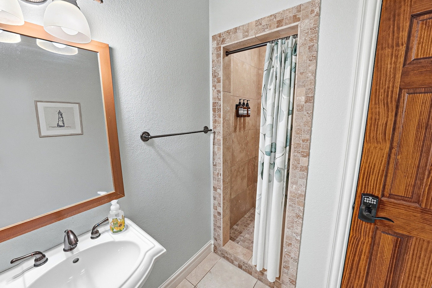 Fresh and inviting bathroom on the main floor with upgraded finishes and an easy-access walk-in shower perfect for families and guests.