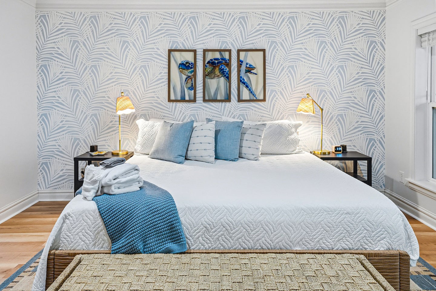 Sink into this beautifully styled king bedroom featuring calming coastal décor, plush bedding, and a peaceful atmosphere designed for restful nights after a day at the beach.