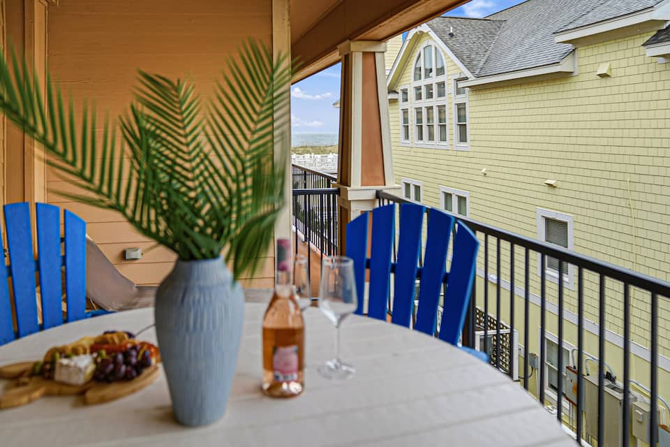 Covered balcony with seating and partial ocean views over the resort grounds