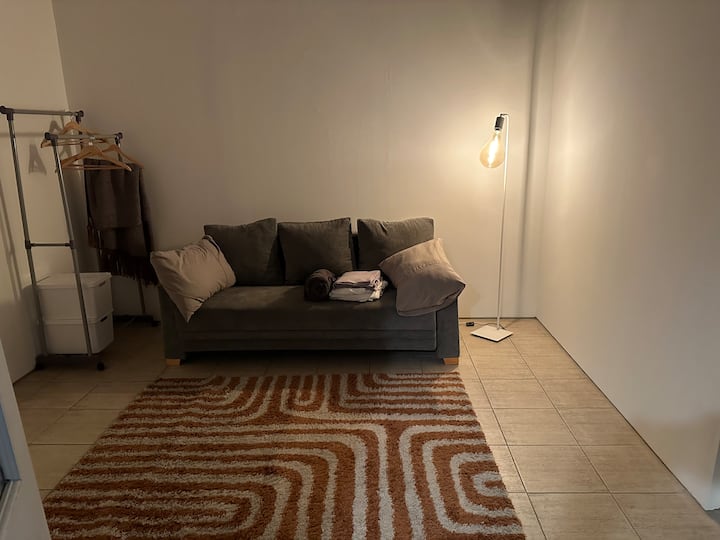 Kitanda cha sofa cha ukubwa maradufu, chenye mashuka na taulo, sehemu ya kukufanya uwe na joto unaposoma au kutazama filamu kwenye kochi.  Rafu ya nguo inayoweza kubebeka, viango na kuhifadhi nguo zako. Taa ya juu na taa ya sakafu kwa ajili ya mwangaza wa karibu zaidi.