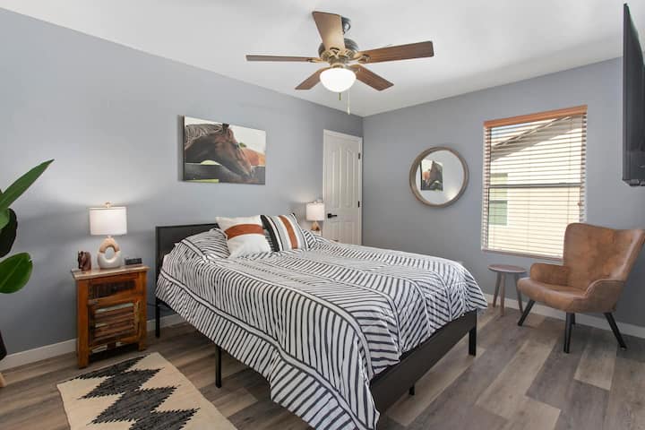 The Horse Room is a stylish upstairs retreat featuring a Queen bed, a cozy leather seating area, and Southwest accents. This bright room includes a ceiling fan and room-darkening shades for a high-quality sleep experience.