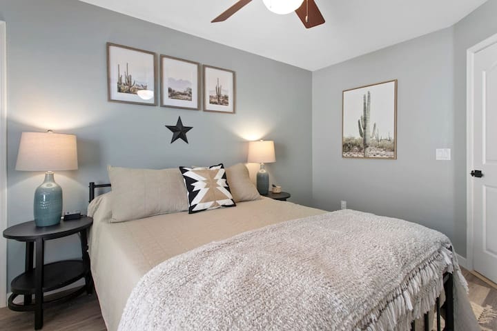 The upstairs Cactus Room offers a serene getaway with a Queen bed and desert-inspired photography. This guest space is equipped with air conditioning, heating, and a ceiling fan to ensure a perfectly comfortable environment.