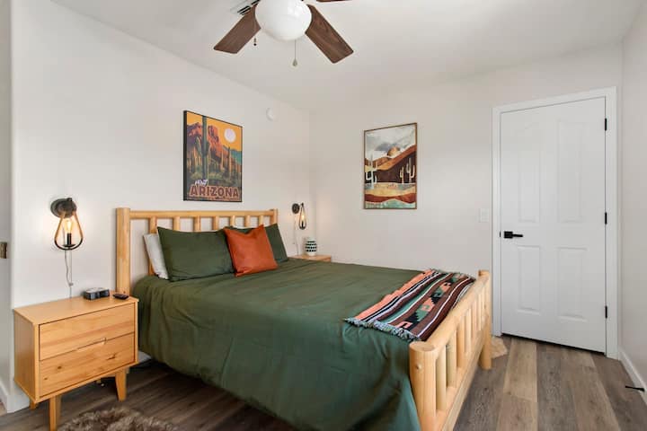 Located on the upper floor, the Arizona Cabin Room is filled with natural light from large windows overlooking the desert landscape. This space is equipped with a wall-mounted TV, creating a clean and comfortable environment for your stay.