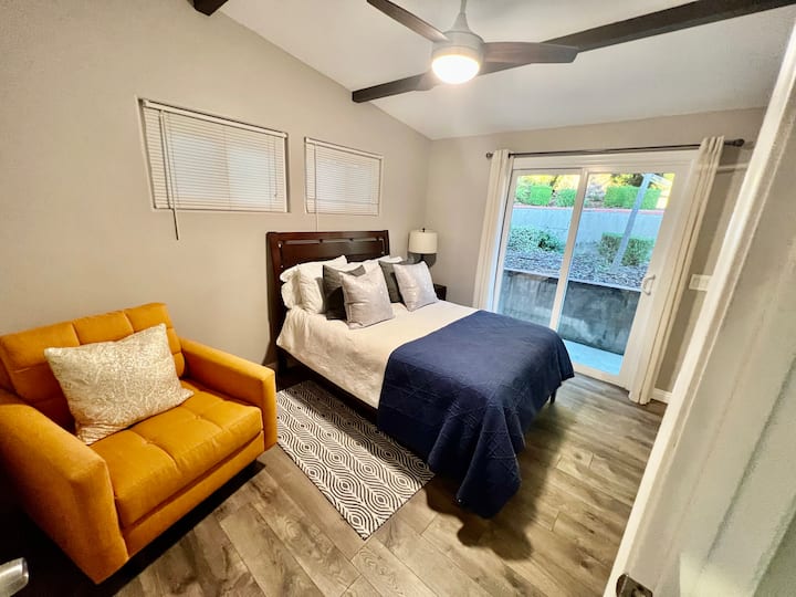 غرفة النوم الثانية مع أبواب منزلقة للفناء والفناء الخلفي.