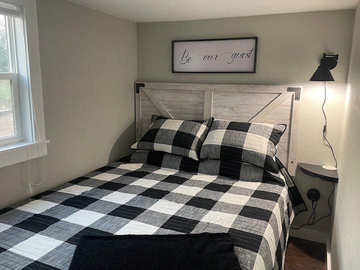 Cama Queen en el piso principal. Pequeña mesa auxiliar, lámpara y enchufes USB para mayor comodidad de carga. Sábanas, toallas y almohadas de repuesto debajo de la cama. 