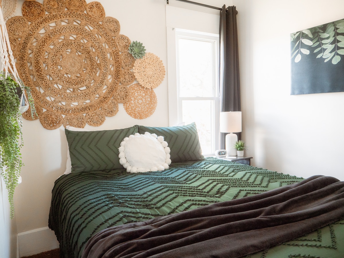 غرفة نوم رئيسية تحتوي على سرير بحجم وسط وتلفزيون بشاشة كبيرة. هناك نزهة في الخزانة مع مكان لتعليق الملابس والرفوف ومروحة محمولة وحقيبة ولعب. 