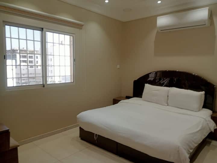 Camera da letto luminosa e confortevole con letto matrimoniale, lenzuola di qualità alberghiera e aria condizionata split. Dispone di una grande finestra con protezioni di sicurezza per bambini, che fornisce luce naturale e maggiore sicurezza per le famiglie. Design tranquillo ideale per un soggiorno rilassante e silenzioso.