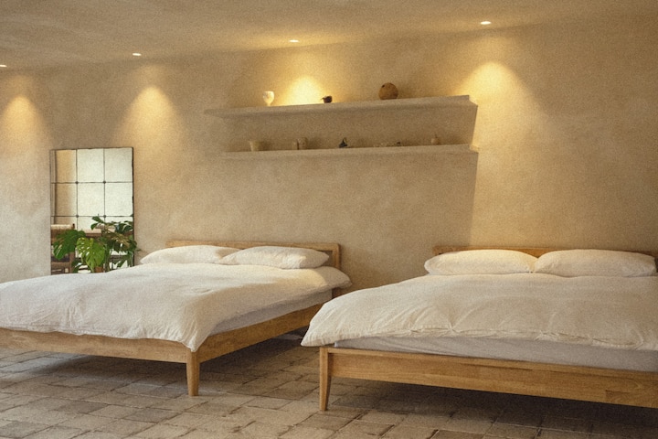 יש מיטה אחת ליד השנייה בחלל אחד.