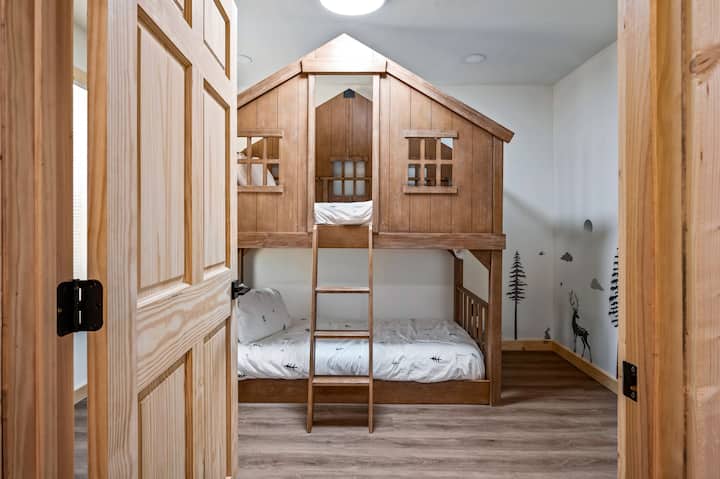 Beautiful bunk room has a twin size bed on each level of the treehouse bunkbed. Light storage is available in the corner under the large television. A pack-n-play crib is available in a bedroom closet. The futon in the gameroom, adds a single bed.