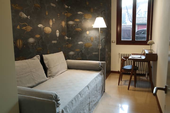 Camera con divano letto e zona studio