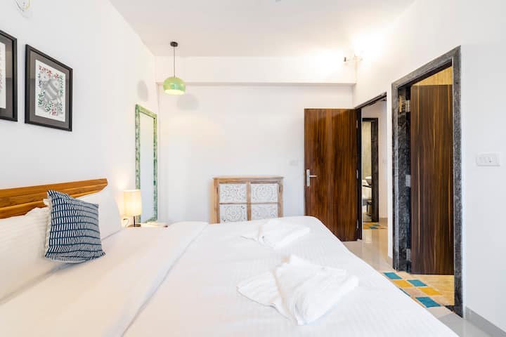 这套位于果阿Assagao的2卧室公寓内的明亮卧室配备了空调、衣柜和舒适的床。