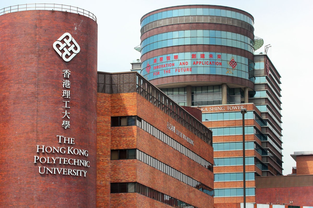 The image shows the exterior of The Hong Kong Polytechnic University, featuring modern and traditional architectural styles. The distinctive brick building displays the university's name prominently, while a taller glass structure is visible in the background, showcasing signage about innovation and application.