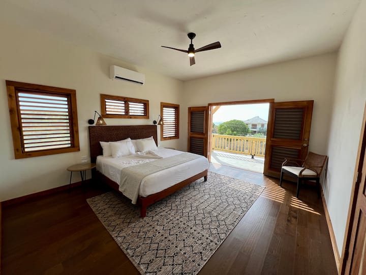 [ベッドルーム2]エンスイートバスルーム付きの上層階のキングベッドルーム。 エアコンと天井ファン。 上階のバルコニーと海の景色へのアクセス。 