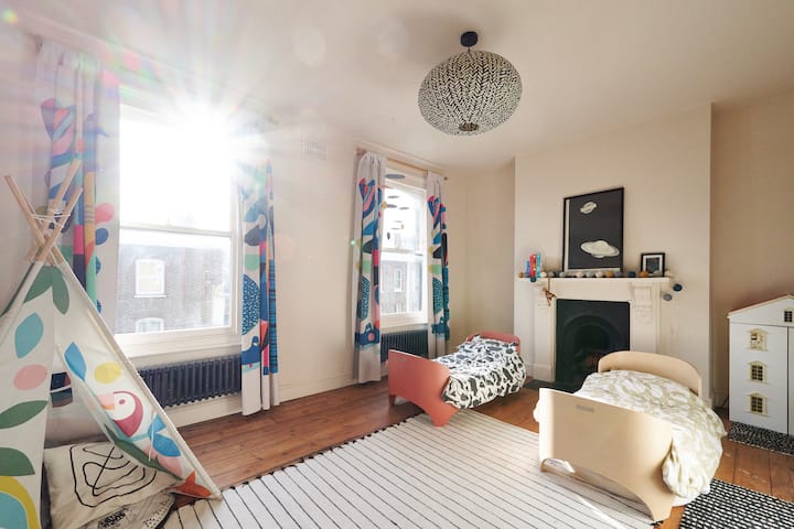 Gran segundo dormitorio luminoso en el segundo piso trasero. Esta habitación tiene 2 camas para niños pequeños y una cama futón doble. Se puede compensar dependiendo de tus necesidades de reserva. Almacenamiento de ropa y características originales