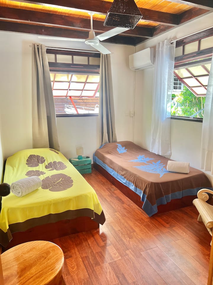 Светла соба со два единечни кревета, идеална за деца или пријатели. Клима уред, мешалка на таванот и складиште. Топла атмосфера со дрвен под.