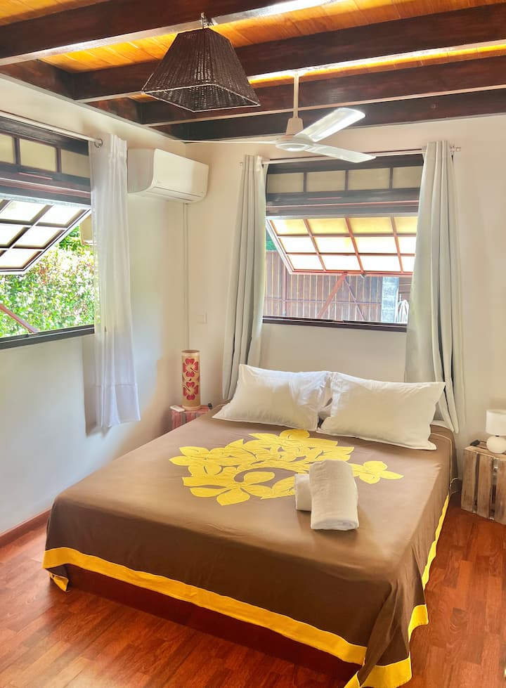 Главна спална соба со брачен кревет (160 x 200 см), клима уред, пивар и голем плакар. Удобна атмосфера и локален декор за потопување во Муреа.