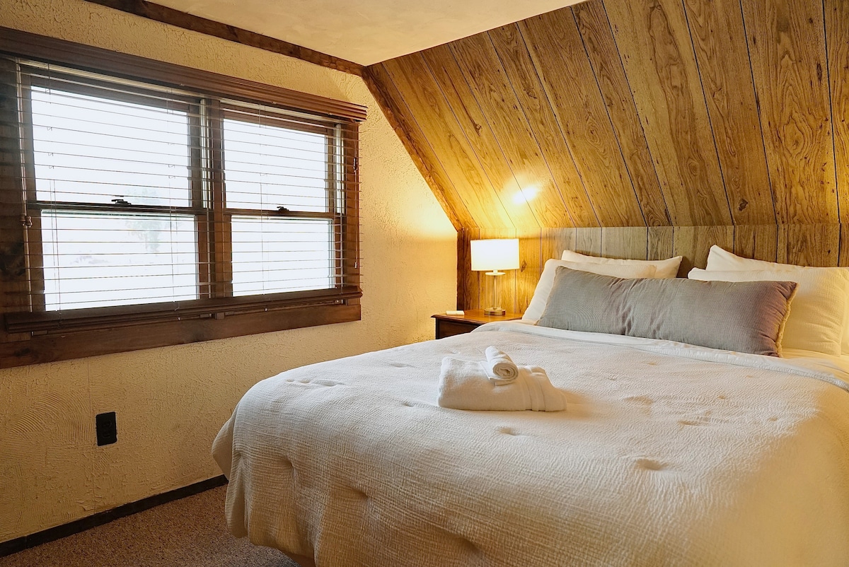 The queen bedroom shares the second floor with two other bedrooms, a half bath, and shelves upon shelves of books. 