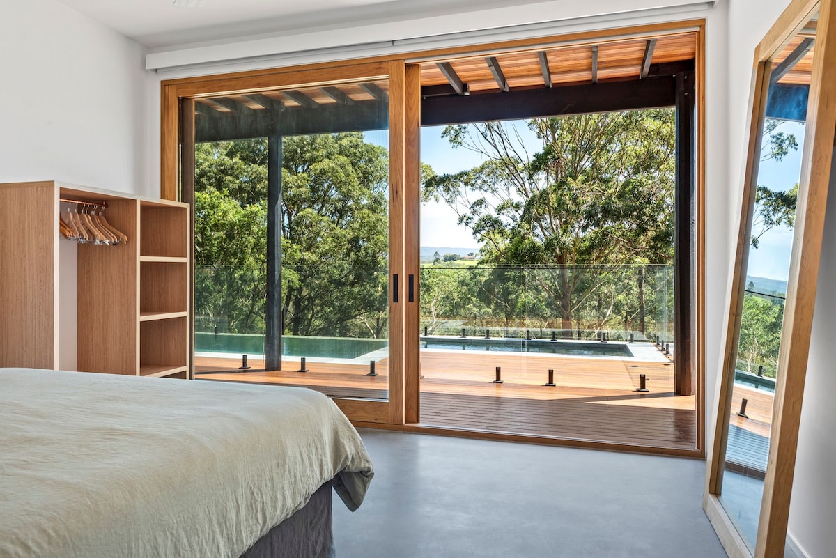 Dormitorio tamaño king que se abre a la terraza, la piscina y el spa.