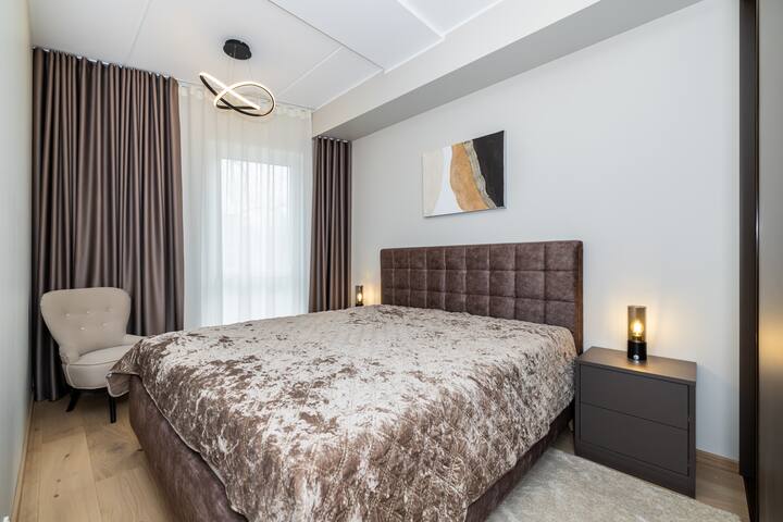 Chambre principale. Fenêtres donnant sur le parc. Calme. Lit king size 180-200 cm. Matelas confortable. Tables de chevet avec lampes de chevet. Il y a un éclairage de base. Grande et spacieuse armoire. 