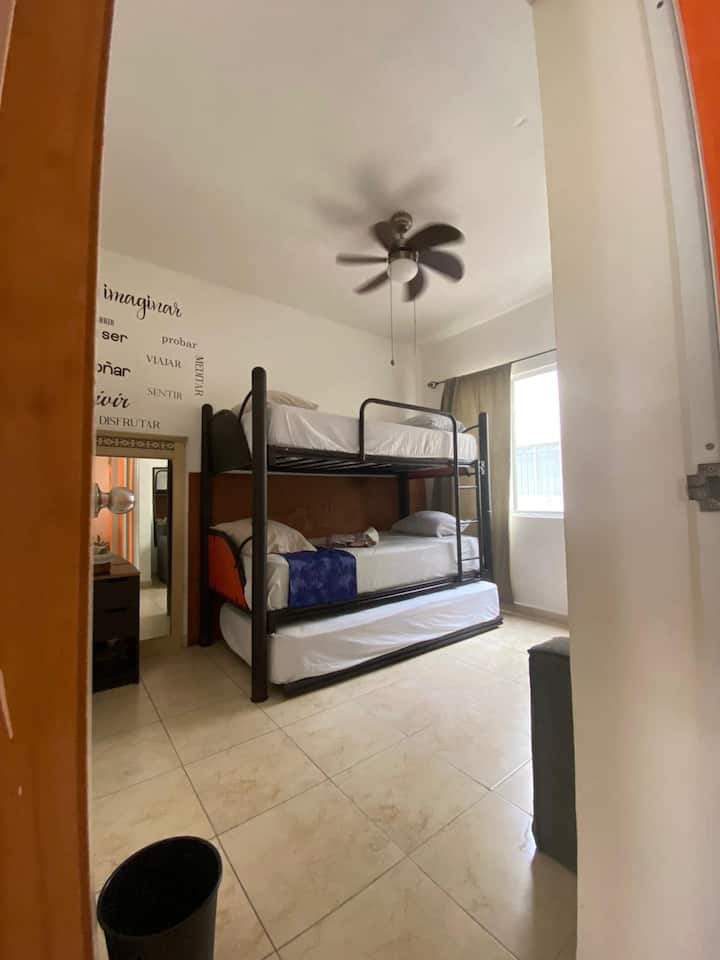 חדר שינה עם מיטת קומותיים (3 מיטות יחיד) ל-3 אנשים, עם מיזוג אוויר ומאוורר תקרה, כמו גם ספה קטנה אחת לנוחיותכם