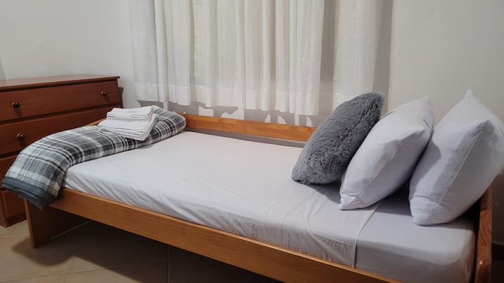 Единечен кревет подготвен за релаксирачка ноќ, перница, постелнина, ќебе и крпи за бањање и лице вклучени во вашиот престој.