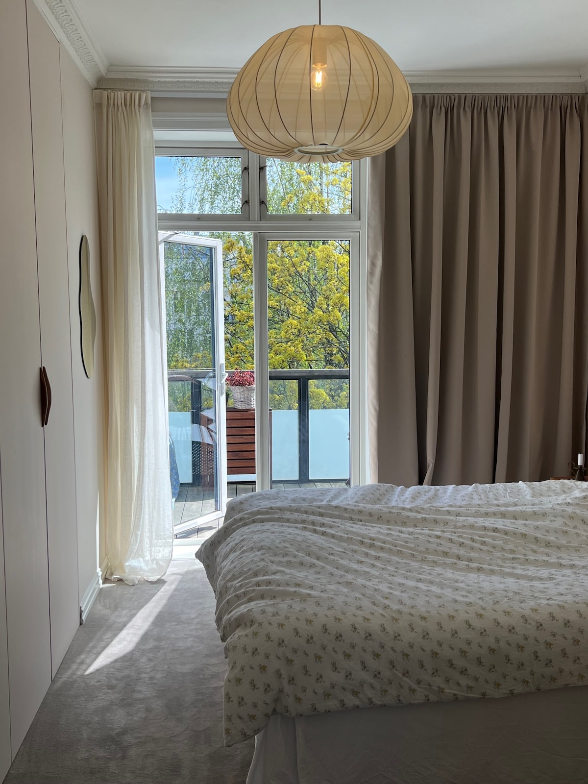 Amplio dormitorio principal de ~16 metros cuadrados con cama matrimonial y salida al balcón