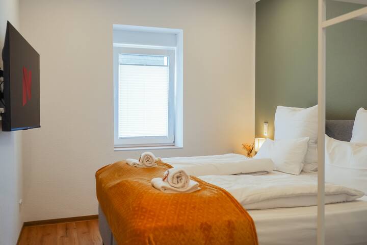 Relax in the box spring bed with comfortable bedding. Equipped with a smart TV and desk, the bedroom offers comfort and functionality.