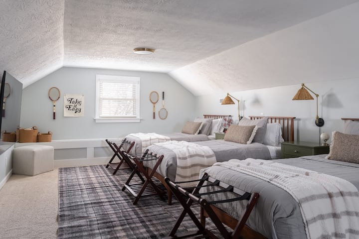 Troisième niveau : chambre avec 3 lits jumeaux, demi-baignoire, aire de jeux et bureau de travail.