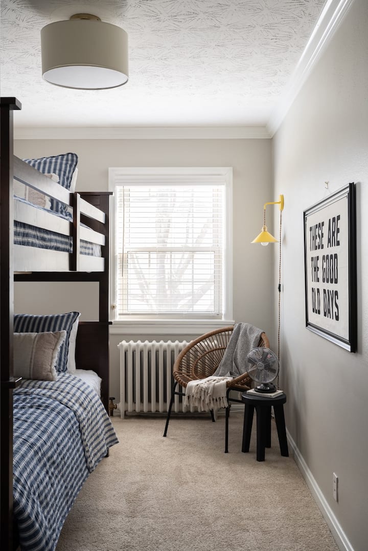 Chambre de deuxième niveau avec lits superposés, buanderie et coin lecture.