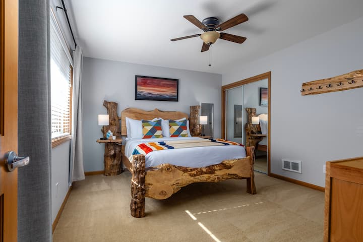 Main bedroom has a queen bed, black-out curtains, reading lights with USB & USB-c outlets, 50" Roku TV and direct access to the bathroom