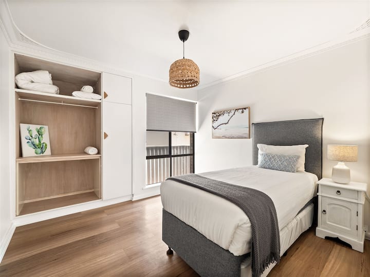 להירגע בחדר השינה הנעים והמואר היטב הזה עם מיטת יחיד מפוארת, עיצוב מסוגנן, אחסון בשפע ותאורה רכה לשינה נינוחה בלילה. 