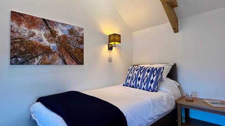 חדר השינה הזה כולל זוג מיטות יחיד עם 1000 מזרנים קפיציים עם סתימות טבעיות. האחסון מסופק בבסיס אחת המיטות + מדפים וחלל תלייה. בחדר יש נופים יפהפיים לאורך העמק.