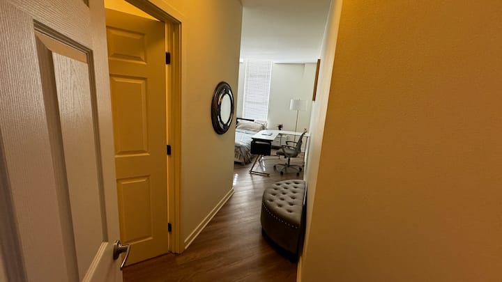 חדר שינה ראשי מודרני עם שולחן עבודה וכיסא  וחדר רחצה פרטי צמוד 