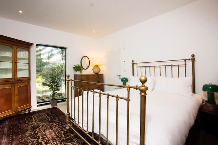 ห้องนอนใหญ่ชั้นล่างเตียงขนาดซูเปอร์คิงไซส์สไตล์วิคตอเรียโบราณ เฟอร์นิเจอร์โบราณโคมไฟข้างเตียงสีเขียวเฮอริเทจ พรมโบราณสไตล์ตะวันออกกลาง