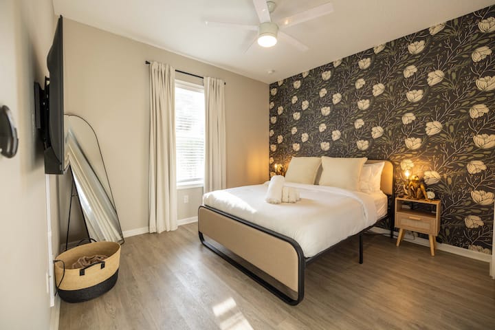 Spálňa s manželskou posteľou má 12-palcový hybridný matrac a 50-palcový inteligentný televízor.