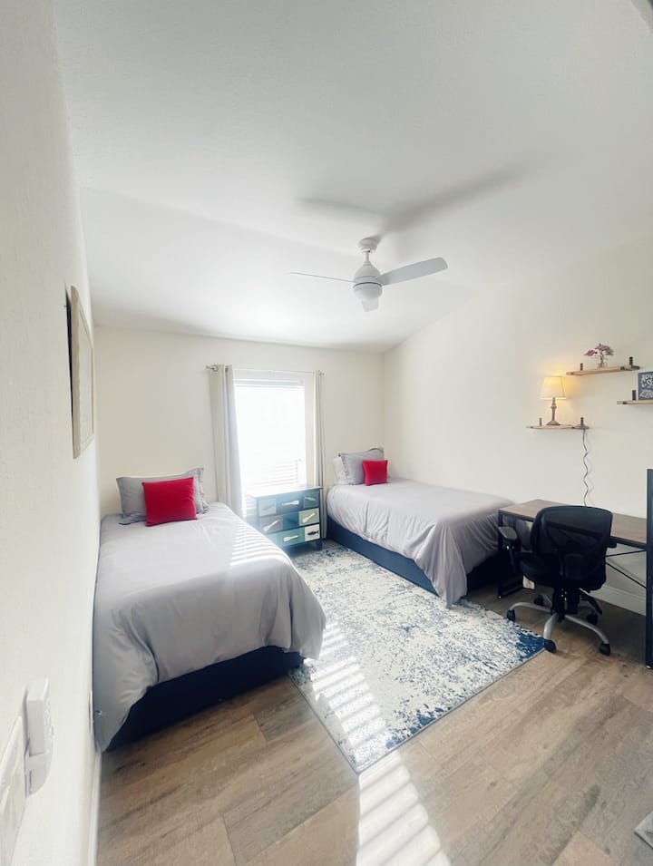 Main floor bedroom next to full bathroom. Two twin-sized memory foam mattress, closet, room darkening shades, desk.