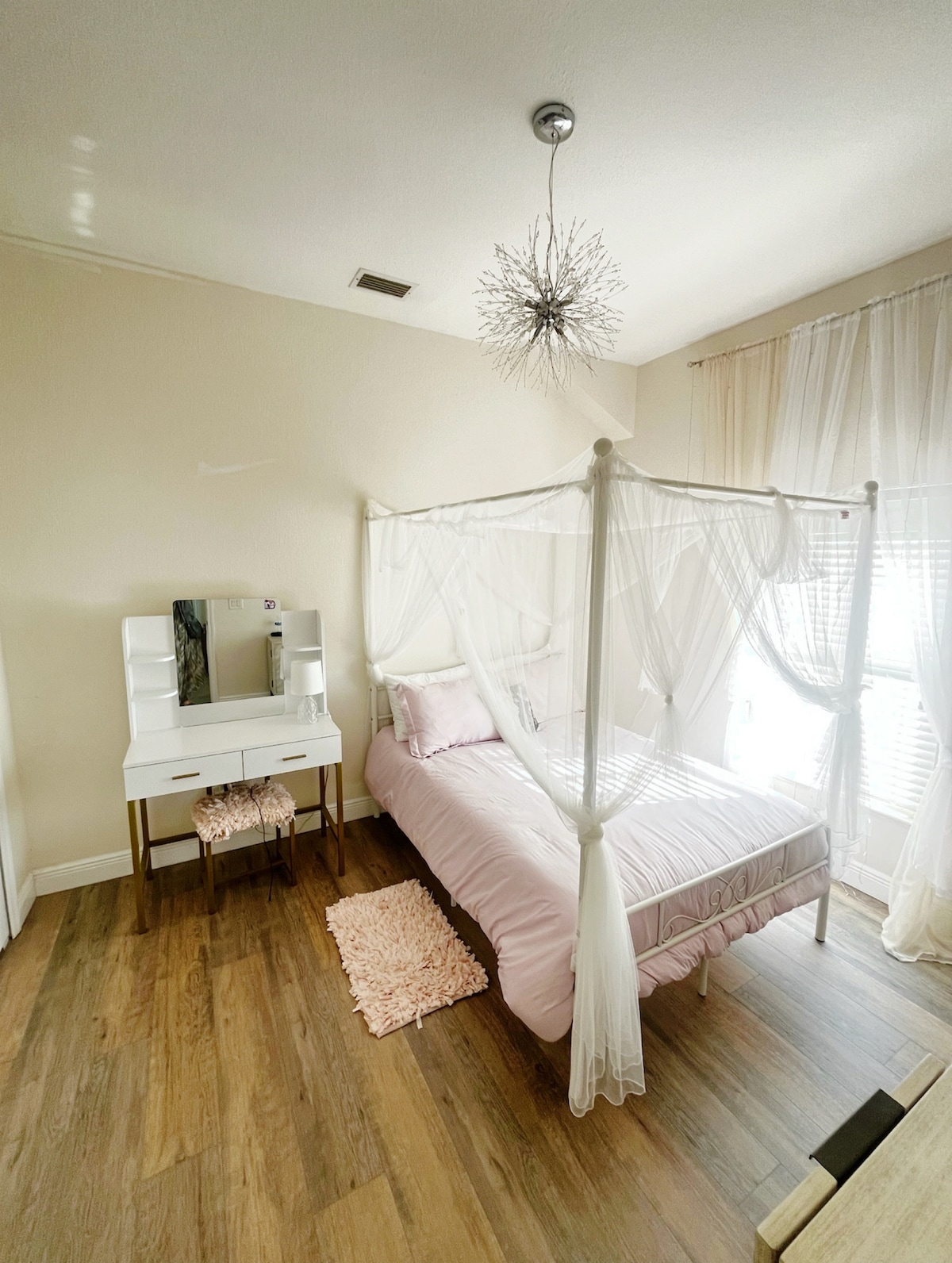 Main floor bedroom next with semi-private full bathroom located at the back of the house. Full-sized memory foam mattress, closet, room darkening shades, vanity, low dresser.