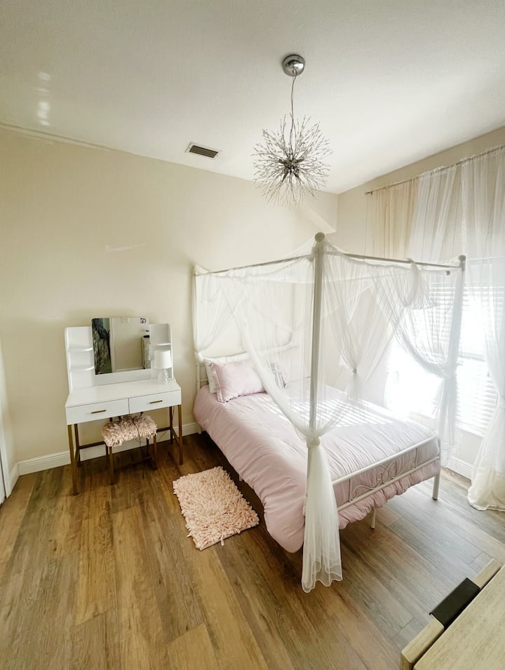 Main floor bedroom next with semi-private full bathroom located at the back of the house. Full-sized memory foam mattress, closet, room darkening shades, vanity, low dresser.