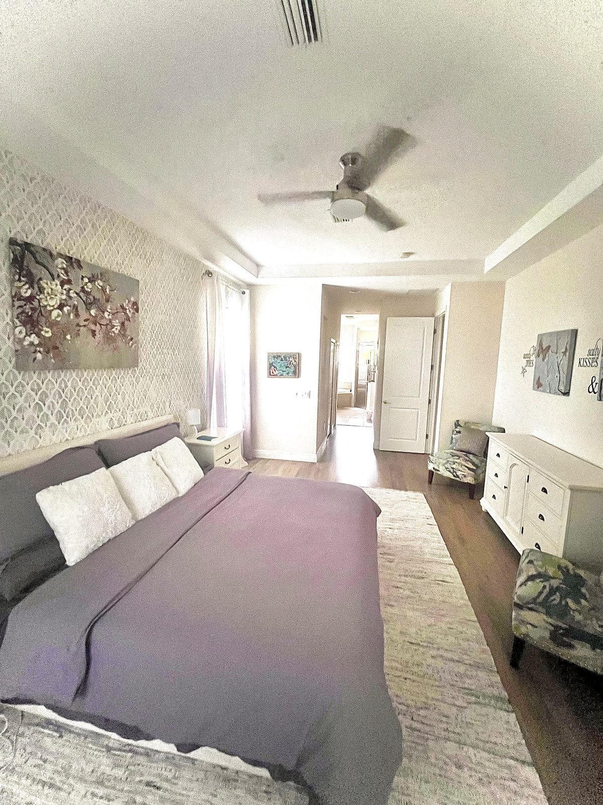 Spacious, main floor master bedroom with attached luxurious bathroom. King-sized memory foam mattress, two walk-in closets, plenty of storage for clothing, sliding patio doors leading to lanai, room darkening shades.