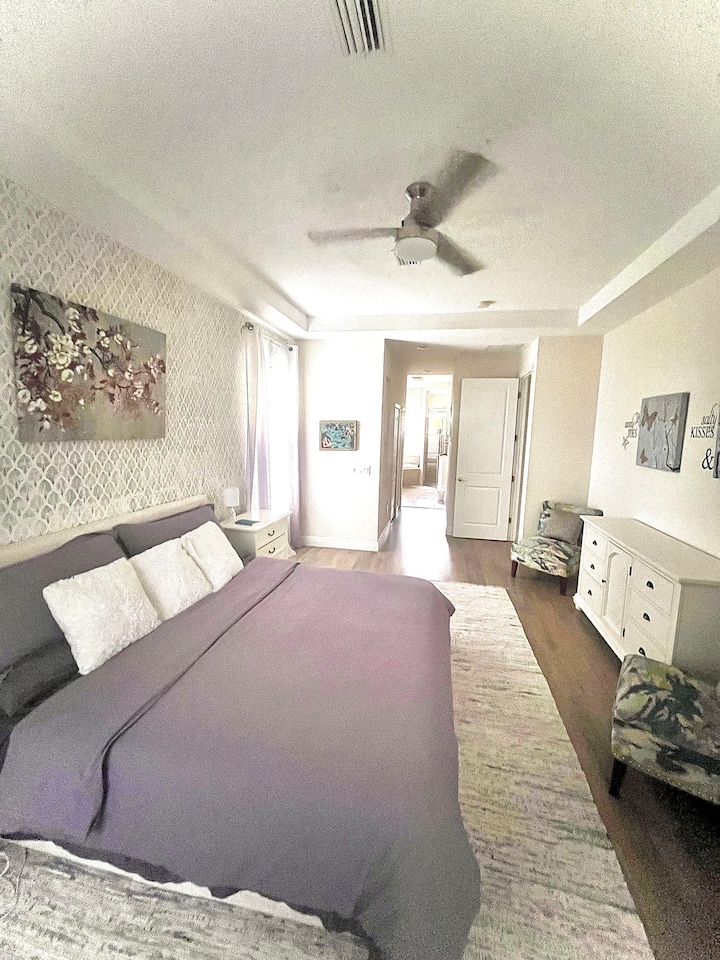 Spacious, main floor master bedroom with attached luxurious bathroom. King-sized memory foam mattress, two walk-in closets, plenty of storage for clothing, sliding patio doors leading to lanai, room darkening shades.
