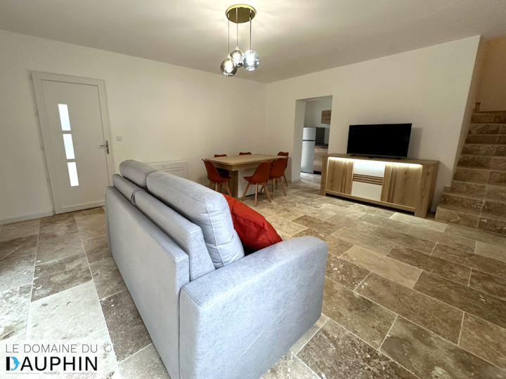 غرفة معيشة مشرقة ومكيفة الهواء مع منطقة لتناول الطعام وتلفزيون ذكي