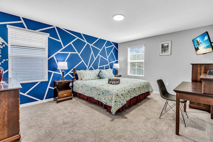 Dhomë gjumi kryesore me një televizor Roku, tavolinë pune dhe banjë kryesore më vete