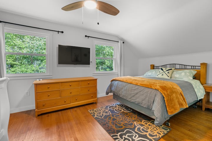 Chumba cha kulala cha ghorofa ya pili ikiwa ni pamoja na kitanda cha kifalme, kitanda cha mtoto, kabati, kabati la kujipambia na televisheni mahiri