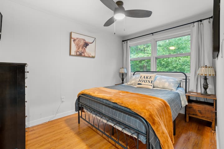 Chumba kikuu cha kulala ikiwa ni pamoja na kitanda cha malkia, kabati, kabati la kujipambia na televisheni mahiri.